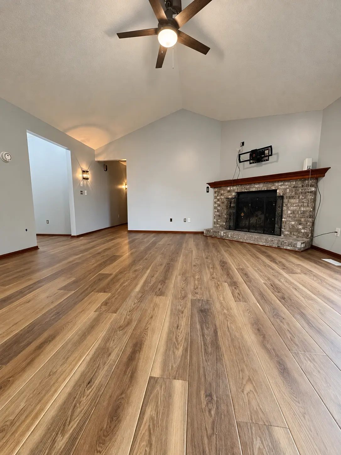 Living area after the improvements, with finished flooring, painted walls, and the fireplace